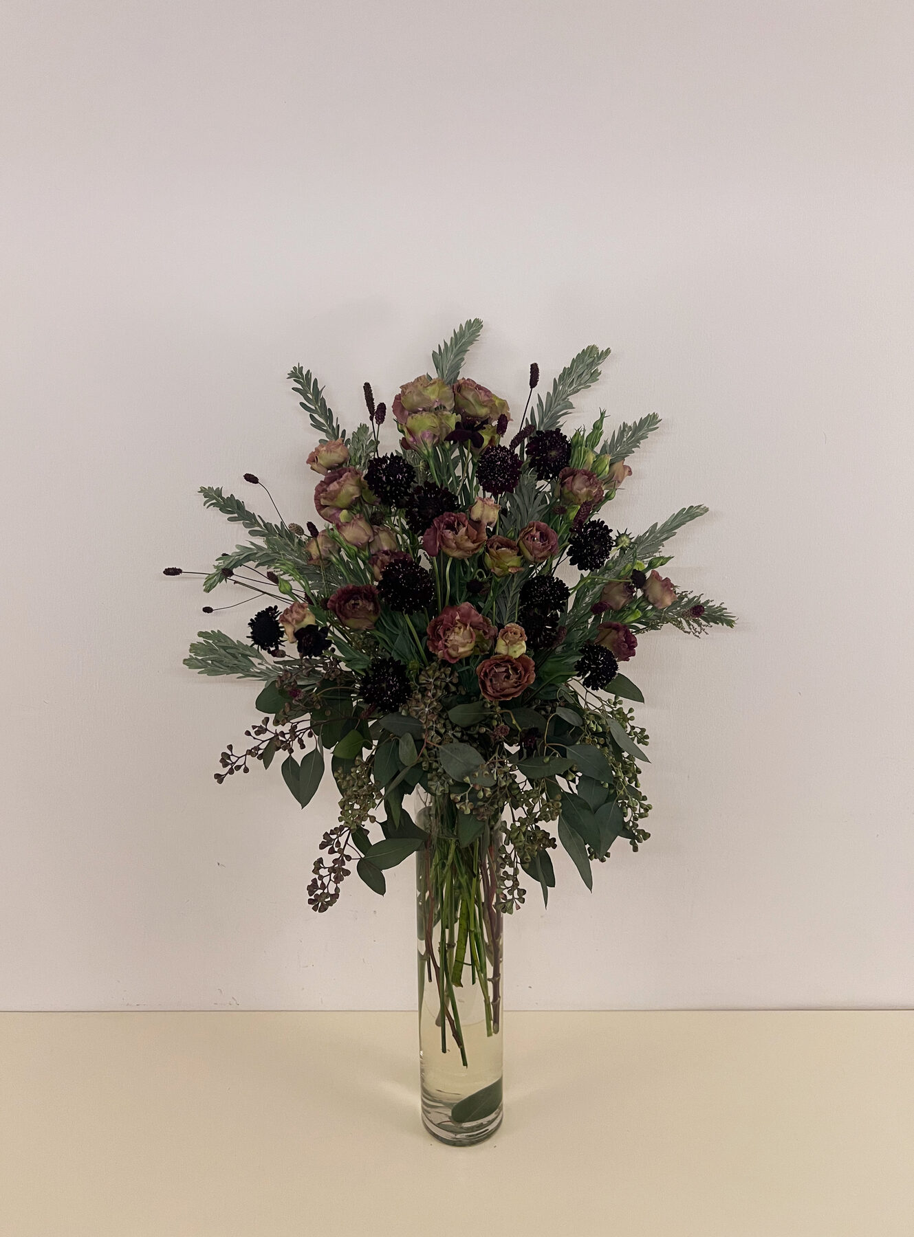 Moody bouquet of dusty rose ranunculus, dark scabiosa, and eucalyptus